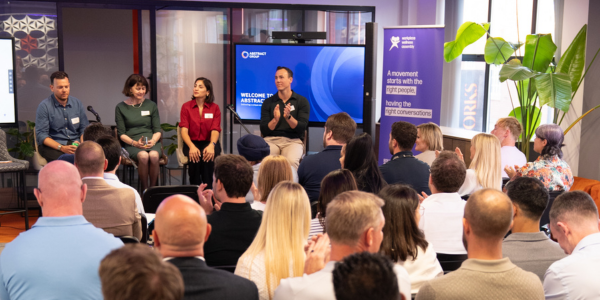 a panel of people sat infront of a crowd