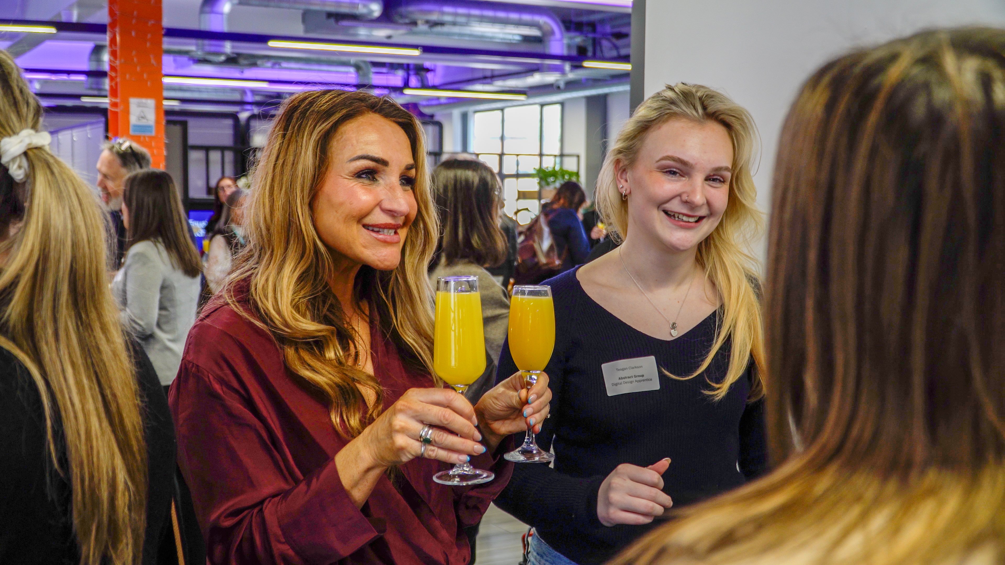 Two people smiling with a drink in hand