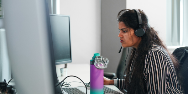 A woman sat at a desktop working on a computer