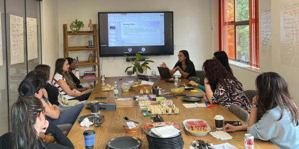 A group of people around a table discussing a presentation