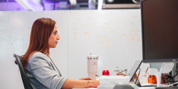 Woman sat at a desk working on a computer