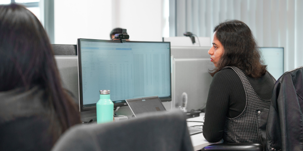 A woman sat working at a desktop computer