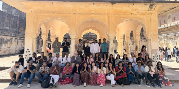 a team of people sat infront of a monument