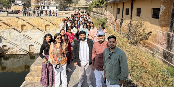a group of people stood in a line, smiling at the camera
