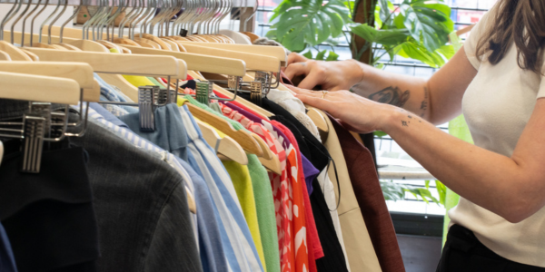 a woman browsing through a railing of clothes