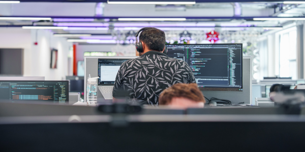  A man facing away looking at a computer screen