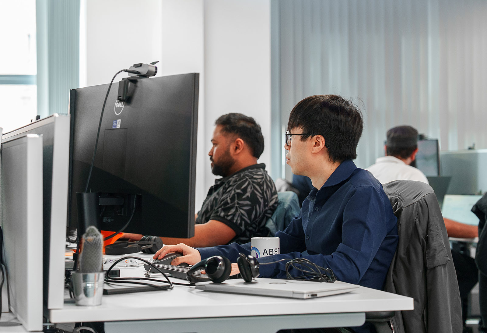Jimmy Chak, Senior Software Engineer, and Kalyan Jothimurugan, software engineer, working side by side at their desks in our office